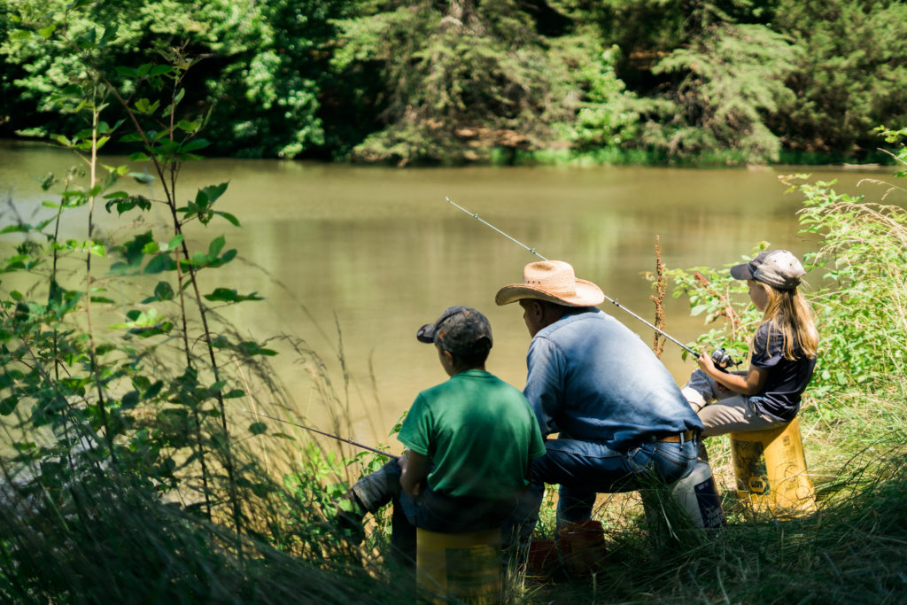 family fishing at pond
