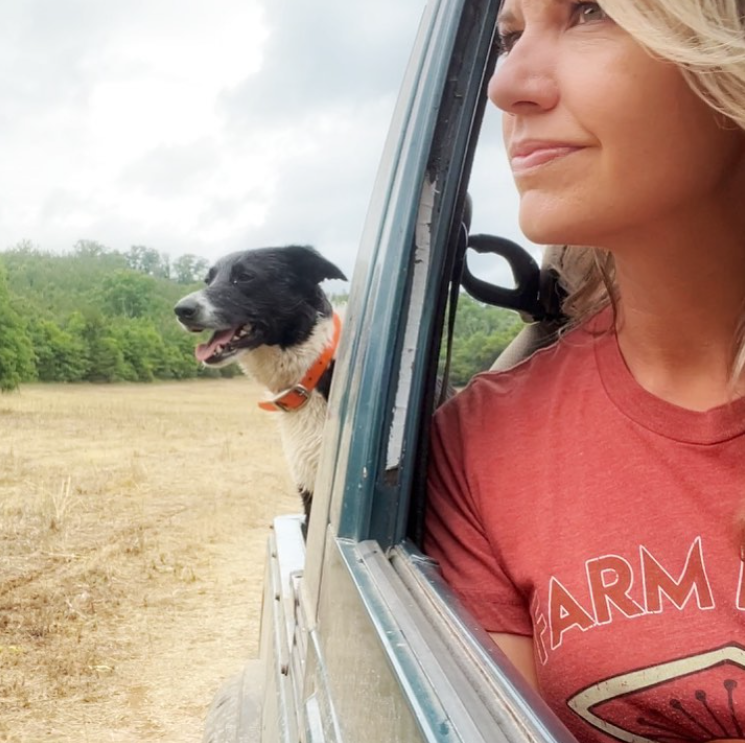 This farm wife and dog leaning out truck window